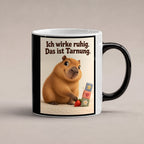 Ruhe mit Plan – Capybara-Tasse mit Spruch. Spruch: Ich wirke ruhig. Das ist Tarnung. Beidseitiges Hochformatmotiv. 1 STUDIO HEISS. Zaubertasse: Wärmeeffekt.