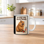 Ruhe mit Plan – Capybara-Tasse mit Spruch. Spruch: Ich wirke ruhig. Das ist Tarnung. Beidseitiges Hochformatmotiv. 2 KUECHE. Weiß.