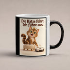 Samtpfotenleitung – Katzentasse mit Spruch. Spruch: Die Katze führt. Ich führe aus. Beidseitige Motivansicht. 1 STUDIO HEISS. Zaubertasse: Wärmeeffekt.