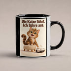 Samtpfotenleitung – Katzentasse mit Spruch. Spruch: Die Katze führt. Ich führe aus. Beidseitige Motivansicht. 1 STUDIO. Innen schwarz.