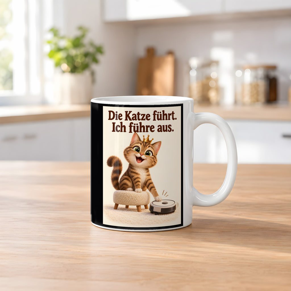 Samtpfotenleitung – Katzentasse mit Spruch. Spruch: Die Katze führt. Ich führe aus. Beidseitige Motivansicht. 2 KUECHE. Weiß.