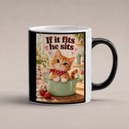 Topfbesetzer – Katzentasse mit Spruch. Spruch: If it fits he sits Beidseitige Motivansicht. 1 STUDIO HEISS. Zaubertasse: Wärmeeffekt.