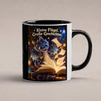 Kleiner Bücherdrache – Drachen-Tasse. Spruch: Kleine Flügel. Große Geschichten. Innen schwarz. 1 STUDIO.