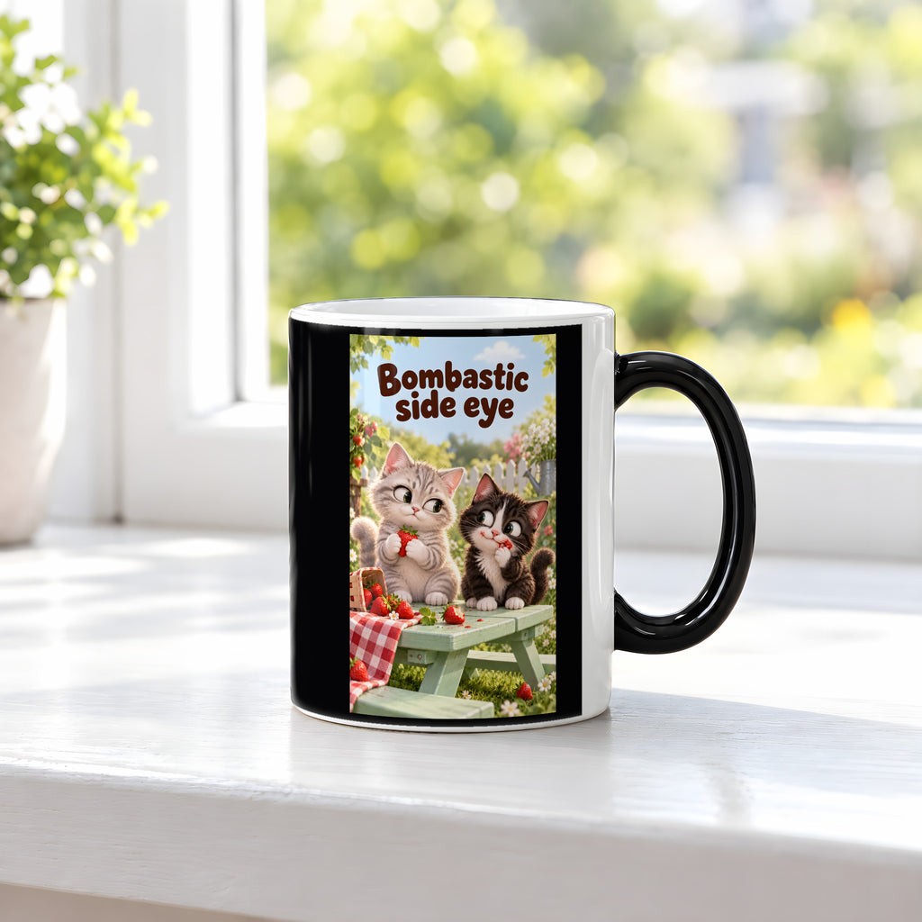 Zwei Kätzchen mit Erdbeeren auf einer Gartenbank werfen sich einen Seitenblick zu. Spruch: Bombastic side eye – Black Edition mit Wärmeeffekt, Ansicht am Fenster.