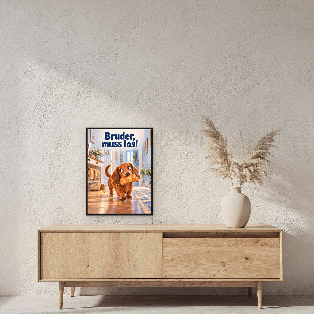 Croissant-Flucht – Gerahmtes Dackelbild. Spruch: Bruder, muss los! 45×60 cm. Schwarzer Holzrahmen ohne Passepartout. 2 RAUM 45x60cm