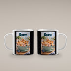 Ein schläfriger Hamster kuschelt in einer grünen Tasse zwischen Blaubeeren und einer kleinen Decke. Spruch: Eepy. – weiße Tasse, beide Motivseiten.