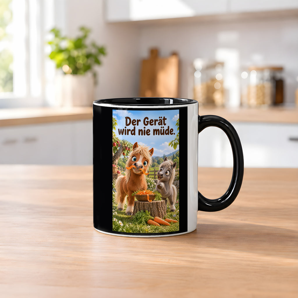 Ein braunes Pony trägt einen Möhrenstreifen als Schnurrbart; daneben lacht ein graues Pony vor einer Schale Möhrenstreifen. Spruch: Der Gerät wird nie müde. – Tasse innen schwarz, Küchenansicht.