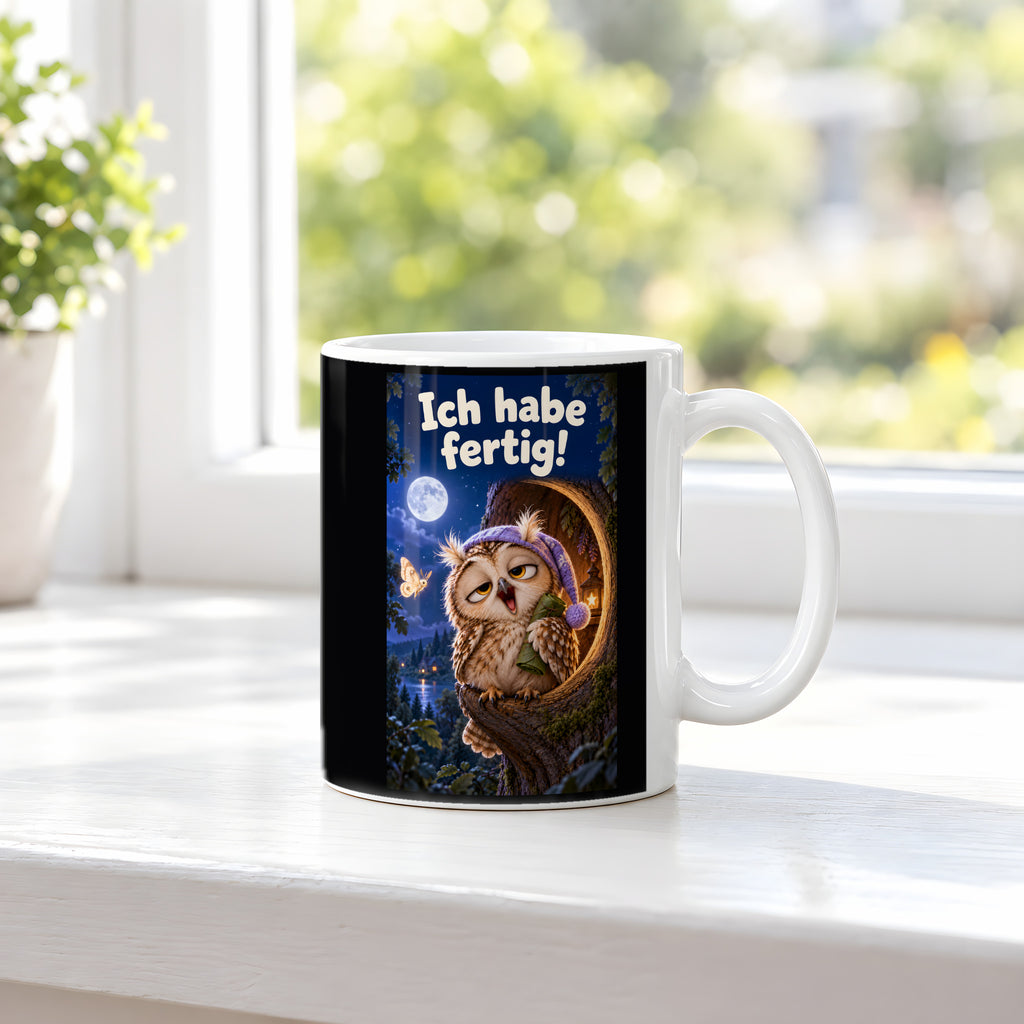 Eine müde Eule mit violetter Schlafmütze gähnt vor einer Baumhöhle unter dem Mond und hält ein kleines Blätterbündel. Spruch: Ich habe fertig! – weiße Tasse, Ansicht am Fenster.