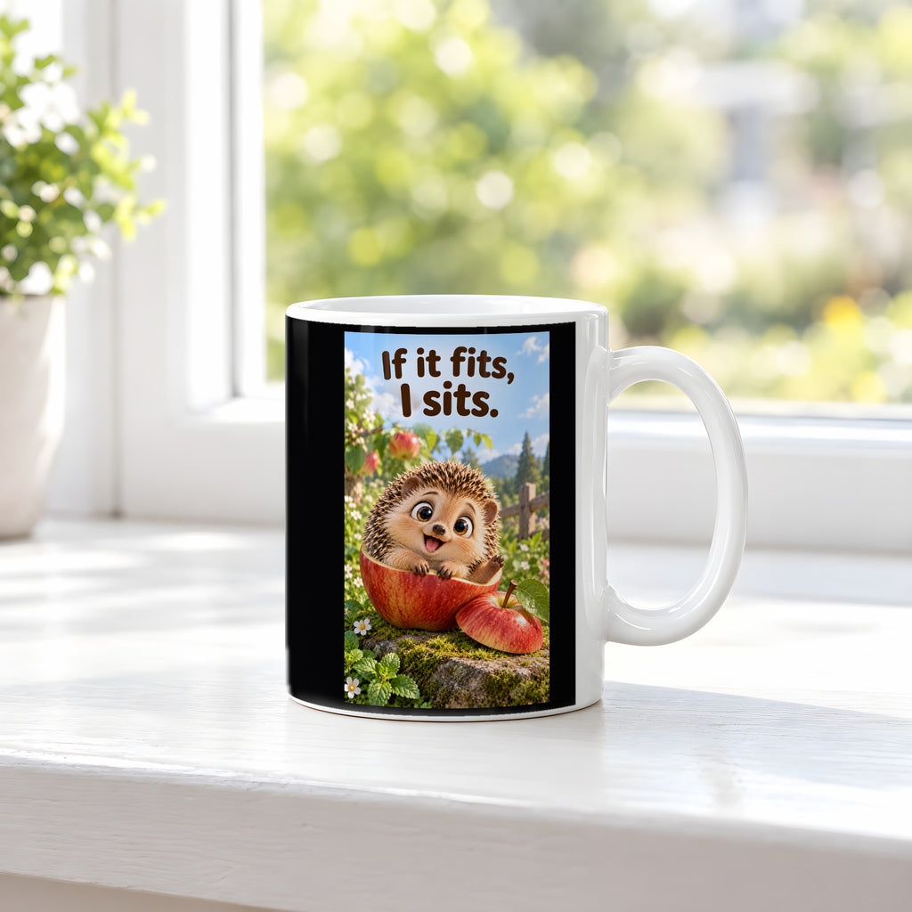 Ein fröhlicher Igel sitzt in einer ausgehöhlten Apfelhälfte im Garten und hebt eine Pfote. Spruch: If it fits, I sits. – weiße Tasse, Ansicht am Fenster.
