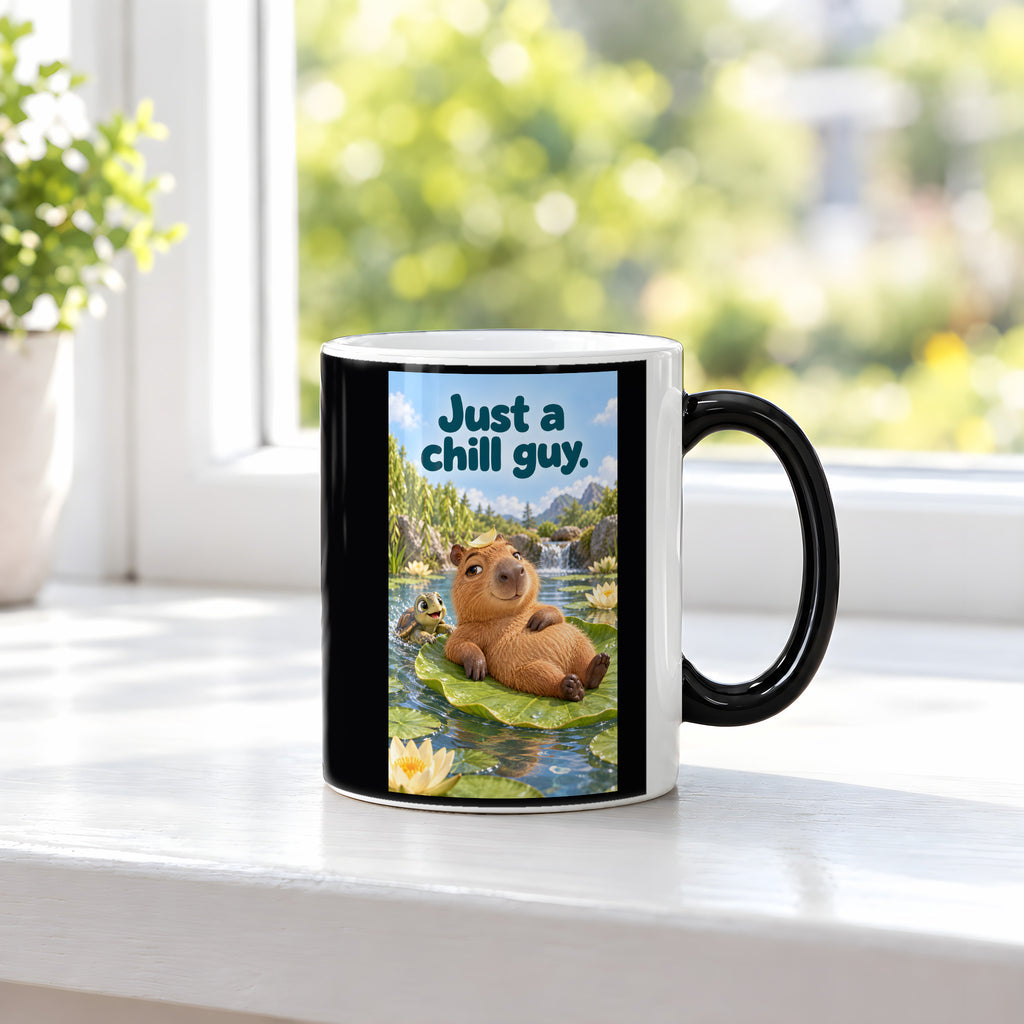 Ein entspanntes Capybara mit einem Blatt auf dem Kopf liegt auf einem großen Seerosenblatt; eine kleine Schildkröte schwimmt daneben. Spruch: Just a chill guy. – Black Edition mit Wärmeeffekt, Ansicht am Fenster.