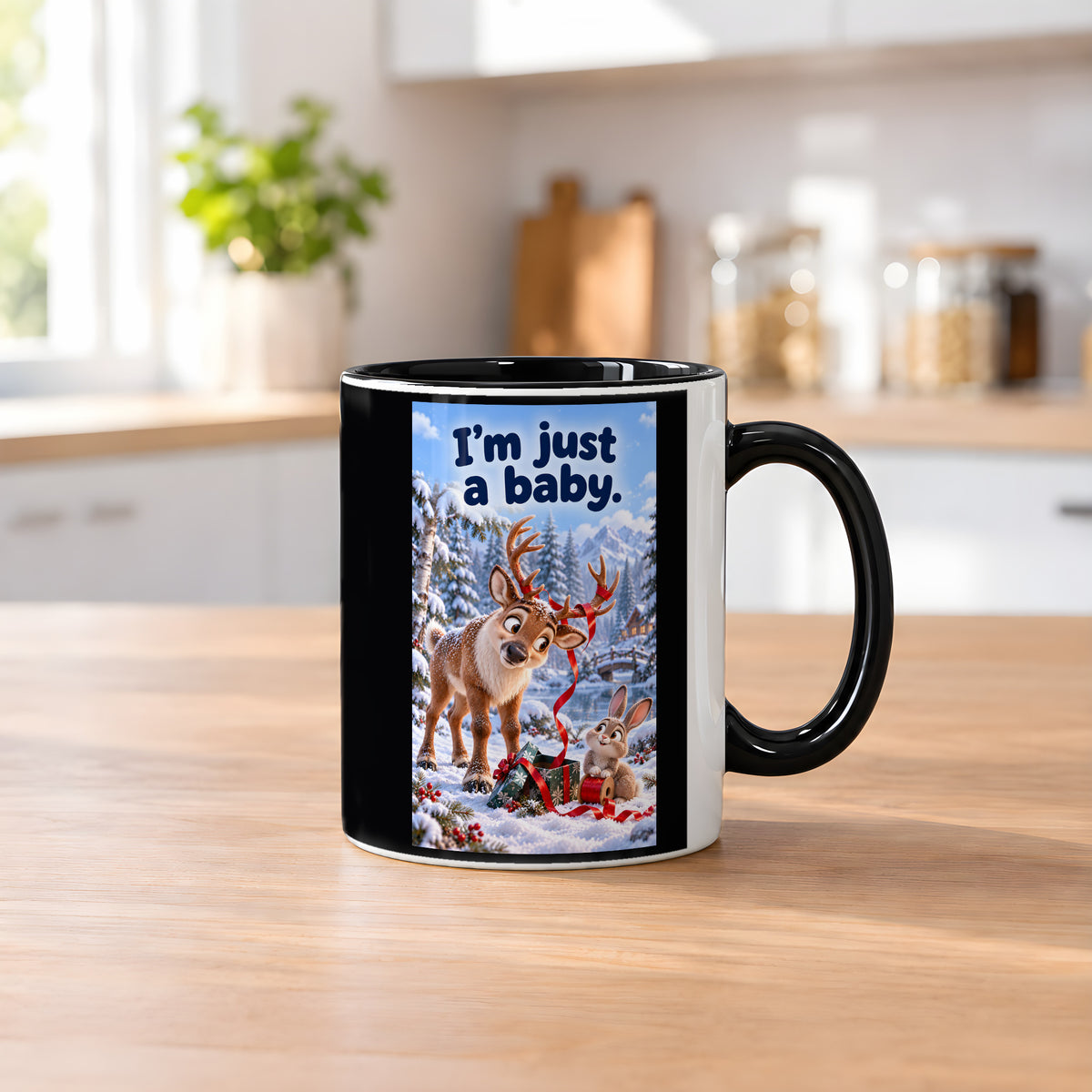Ein Rentier mit rotem Geschenkband im Geweih blickt zu einem Kaninchen mit einer Bandrolle neben einem Geschenk im Schnee. Spruch: I'm just a baby. – Tasse innen schwarz, Küchenansicht.