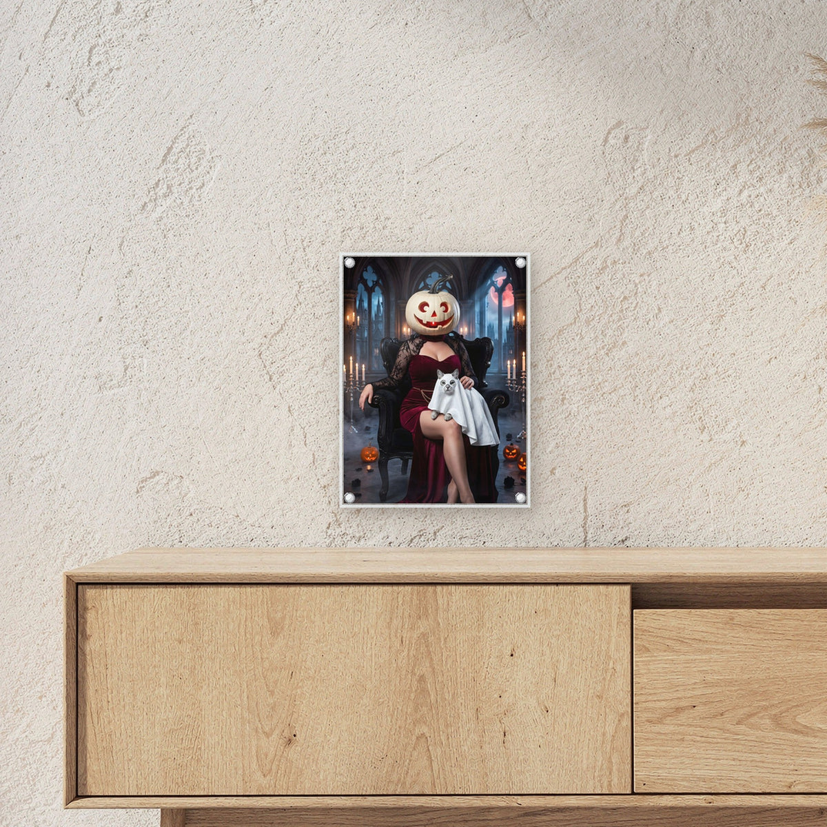 Die Kürbis-Dame – Dame mit Kürbiskopf im roten Samtkleid auf dem Sessel mit Katzengespenst im Arm, auf Acrylglas mit Edelstahl-Abstandshaltern, über einem Sideboard, zeigt die Größe im Raum