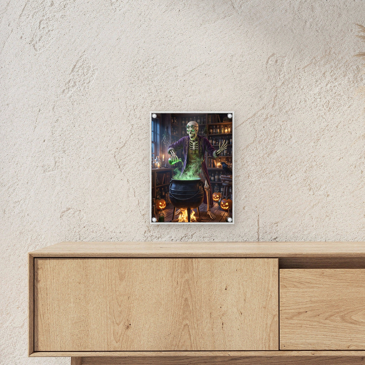 Der Alchemist – Skelett braut grünen Trank am Kessel in der Hexenküche, auf Acrylglas mit Edelstahl-Abstandshaltern, über einem Sideboard, zeigt die Größe im Raum