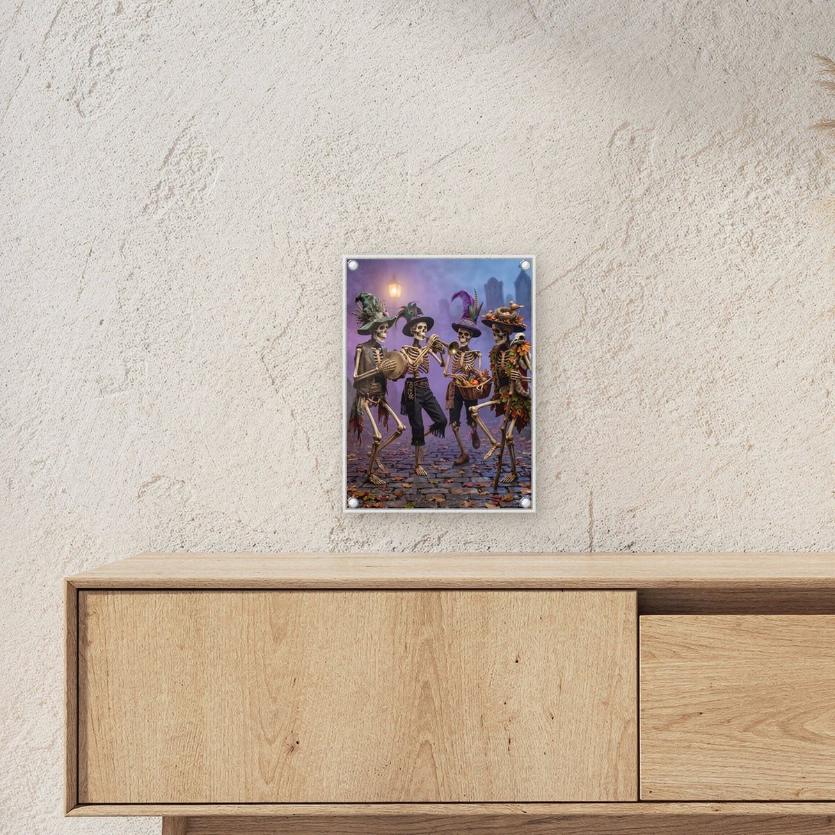Die Knochenkapelle – Vier Skelette mit bunten Hüten spielen als Kapelle durch die Gassen, auf Acrylglas mit Edelstahl-Abstandshaltern, über einem Sideboard, zeigt die Größe im Raum