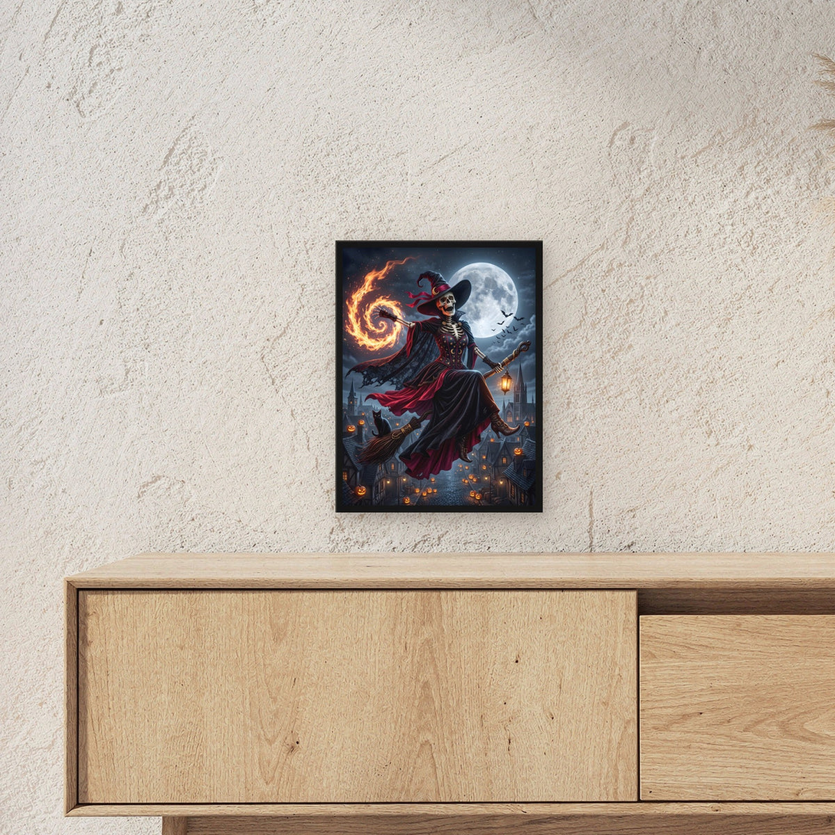 Die Besenkönigin – Skelett-Hexe fliegt auf dem Besen mit Feuerspirale über die Stadt, im schwarzen Holzrahmen, über einem Sideboard, zeigt die Größe im Raum
