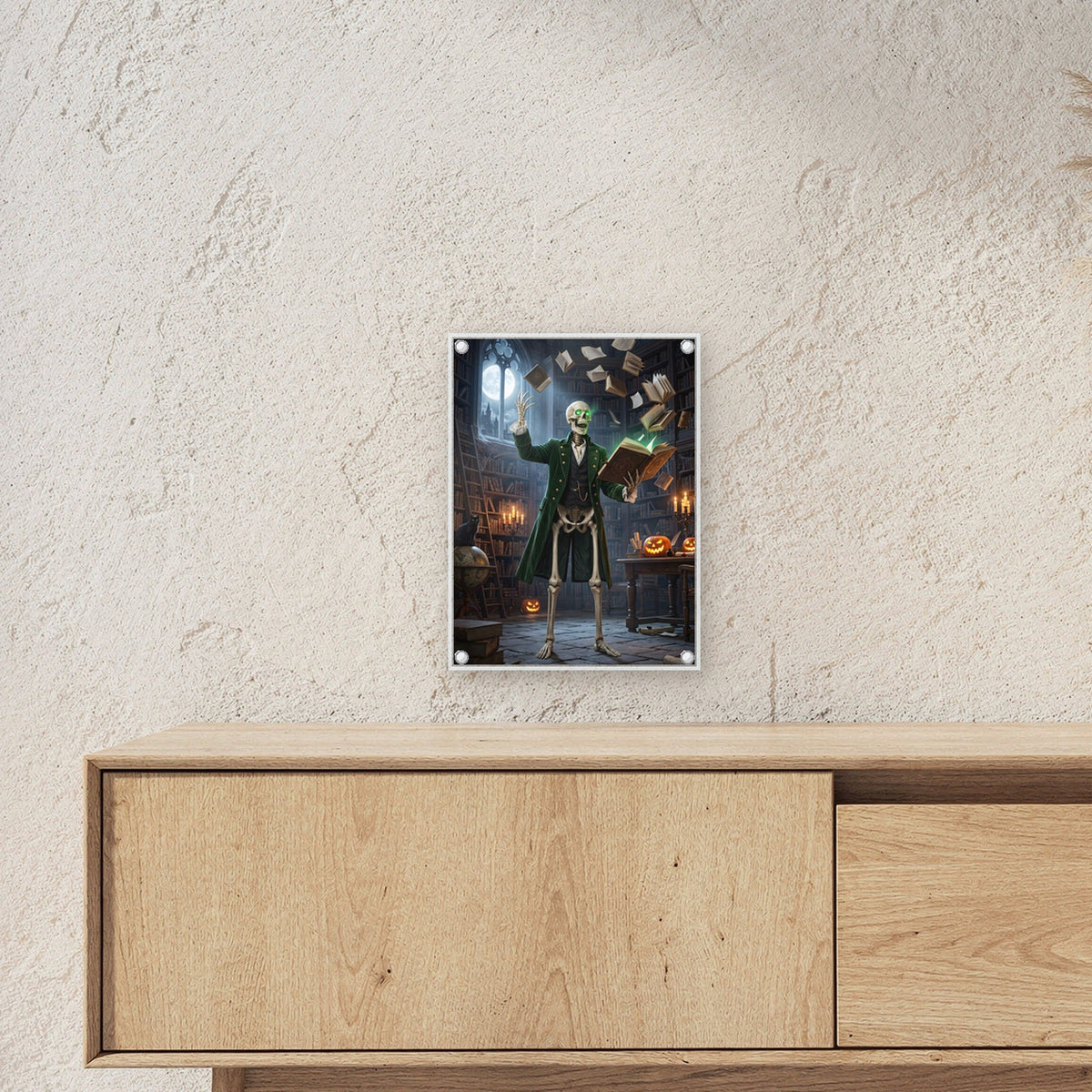 Der Bibliothekar – Skelett mit leuchtenden Augen lässt Bücher durch die Bibliothek fliegen, auf Acrylglas mit Edelstahl-Abstandshaltern, über einem Sideboard, zeigt die Größe im Raum
