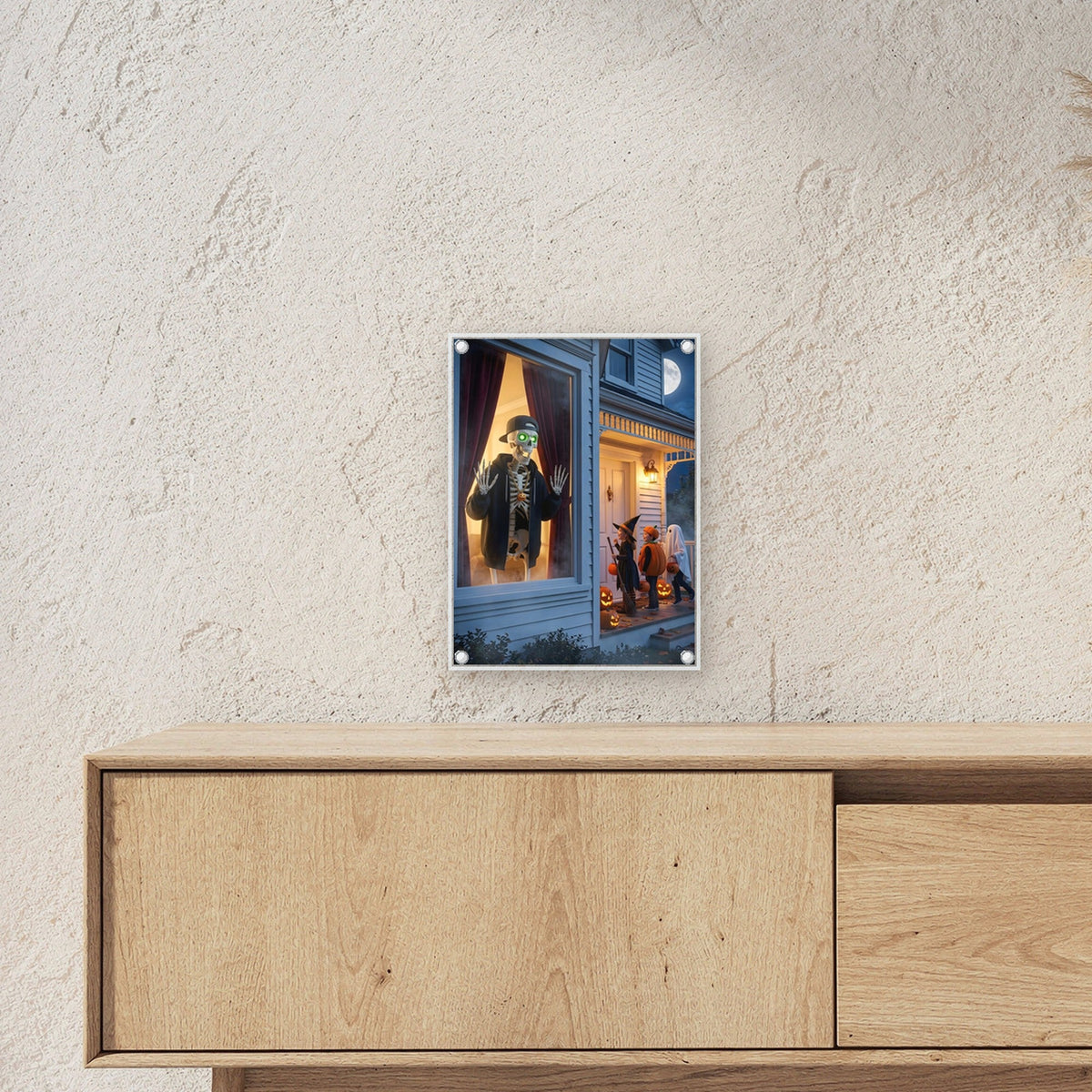 Der Fenstergast – Skelett mit Basecap winkt aus dem Fenster den Kindern im Kostüm auf der Veranda, auf Acrylglas mit Edelstahl-Abstandshaltern, über einem Sideboard, zeigt die Größe im Raum