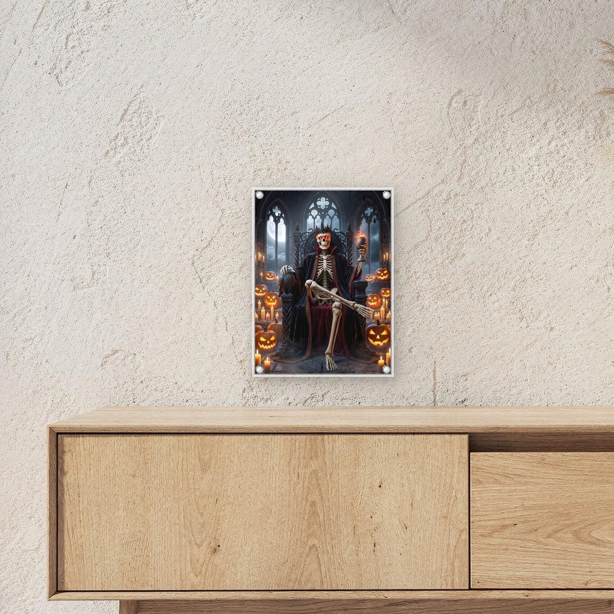 Der Kürbiskönig – Skelett-König mit Krone und Kelch auf dem Thron zwischen Kürbissen, auf Acrylglas mit Edelstahl-Abstandshaltern, über einem Sideboard, zeigt die Größe im Raum