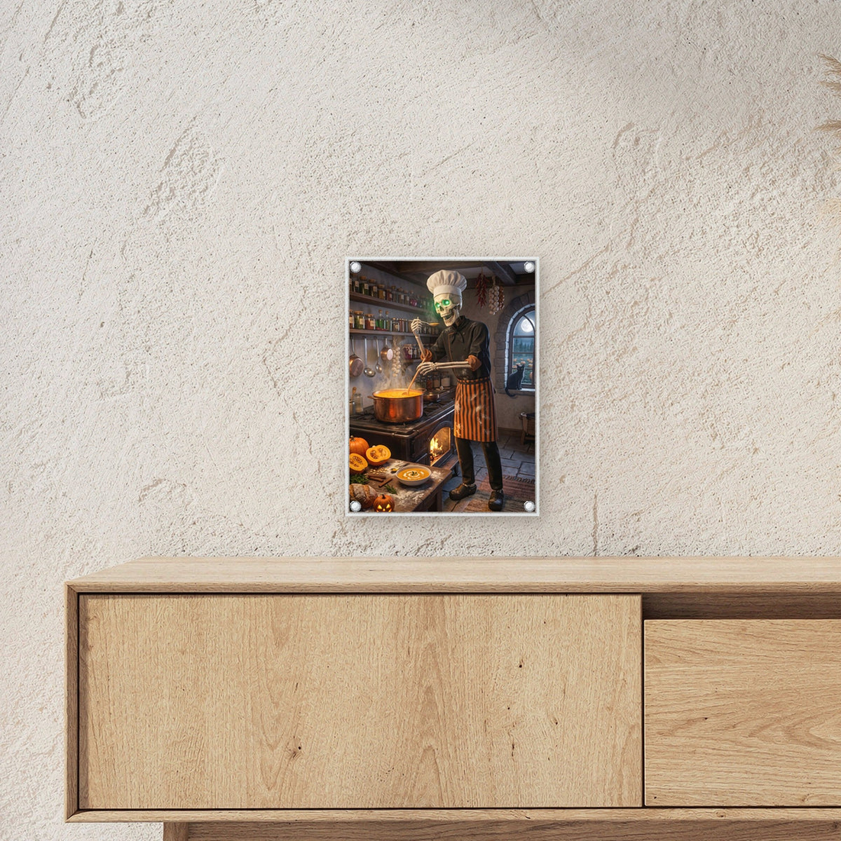 Der Suppenkoch – Skelett mit Kochmütze rührt Kürbissuppe in der alten Küche, auf Acrylglas mit Edelstahl-Abstandshaltern, über einem Sideboard, zeigt die Größe im Raum