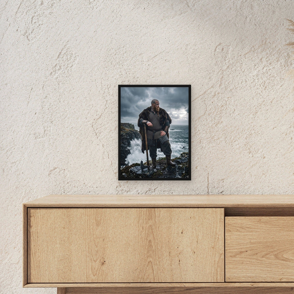 Der Küstenwächter – Wikinger mit Axt auf den Klippen über der Brandung, im schwarzen Holzrahmen, über einem Sideboard