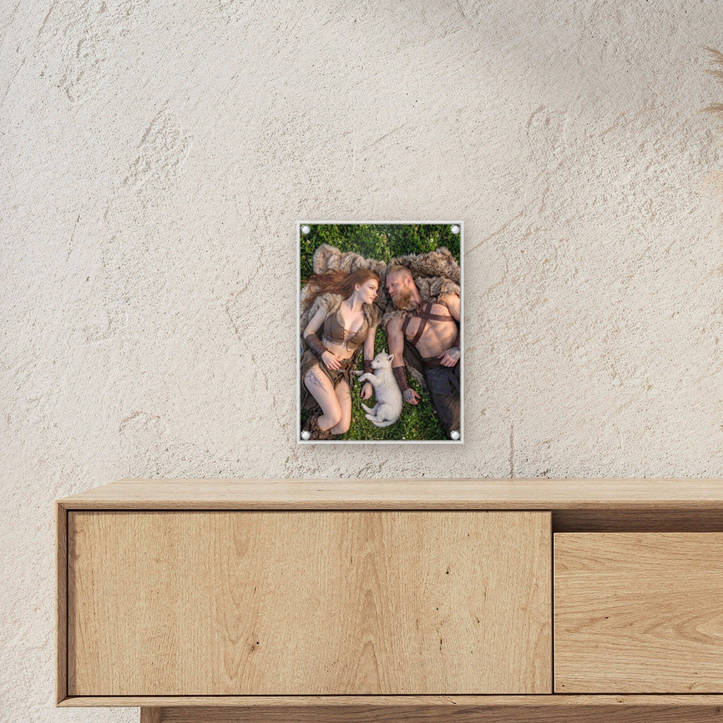Rast im Klee – Wikingerpaar liegt mit weißem Welpen im Klee, auf Acrylglas mit Edelstahl-Abstandshaltern, über einem Sideboard, zeigt die Größe im Raum