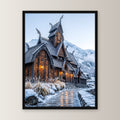Stabkirche im Schnee – Nordische Stabkirche mit Drachenköpfen vor verschneiten Bergen, im schwarzen Holzrahmen, gerade von vorn an heller Wand