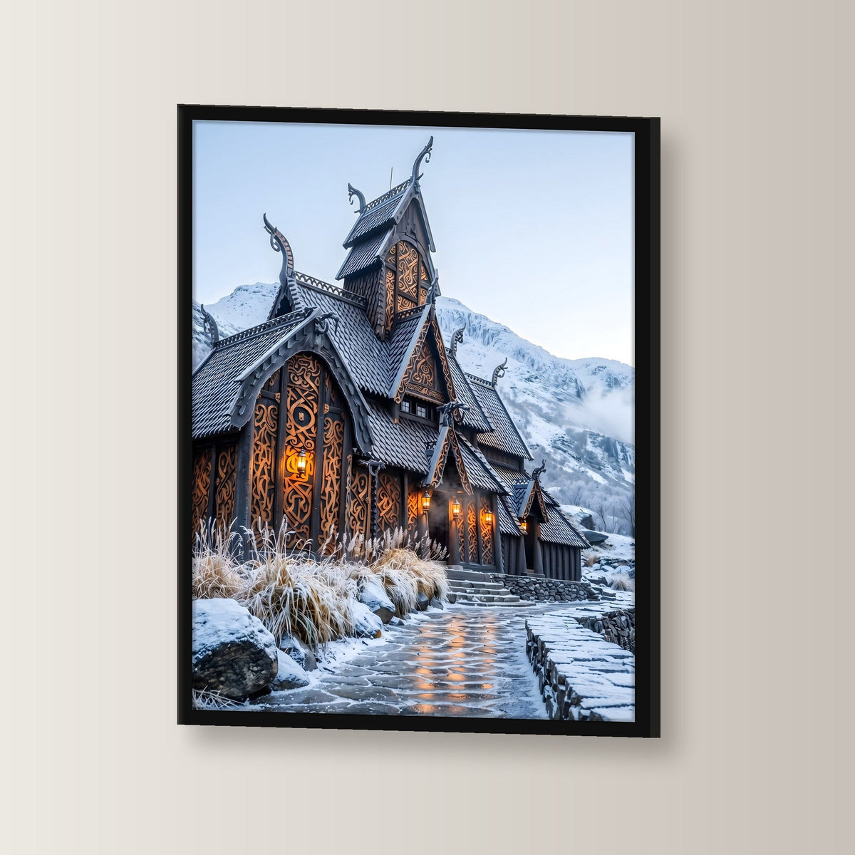 Stabkirche im Schnee – Nordische Stabkirche mit Drachenköpfen vor verschneiten Bergen, im schwarzen Holzrahmen, leicht gedreht an der Wand