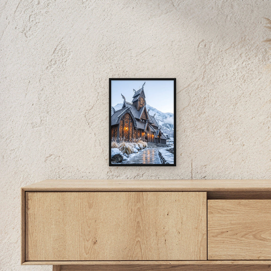 Stabkirche im Schnee – Nordische Stabkirche mit Drachenköpfen vor verschneiten Bergen, im schwarzen Holzrahmen, über einem Sideboard, zeigt die Größe im Raum