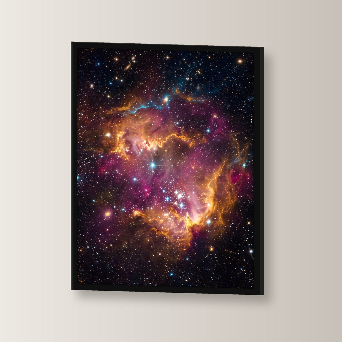 Die Sternenwiege – Sternennebel in Orange und Magenta mit jungen Sternen, im schwarzen Holzrahmen, leicht gedreht an der Wand