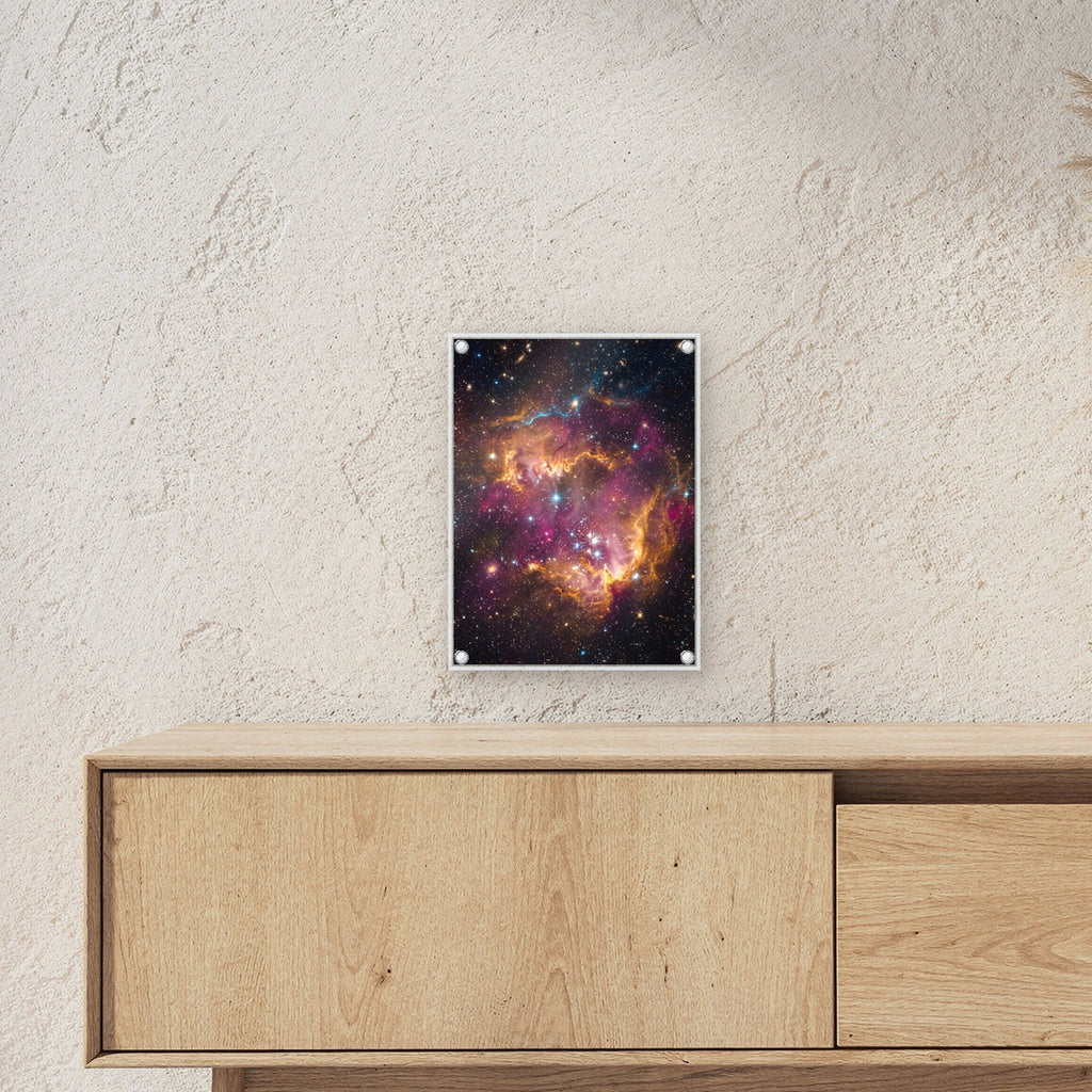 Die Sternenwiege – Sternennebel in Orange und Magenta mit jungen Sternen, auf Acrylglas mit Abstandshaltern, über einem Sideboard